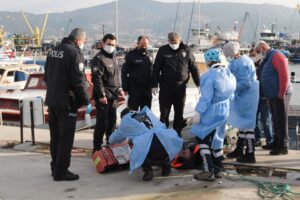 İzmir'in Foça ilçesindeki balıkçı barınağındaki tekneler arasında bir erkek cesedi