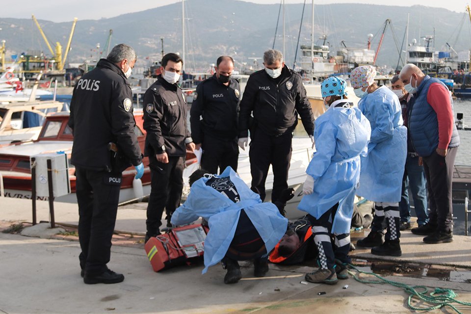 İzmir'in Foça ilçesindeki balıkçı barınağındaki tekneler arasında bir erkek cesedi