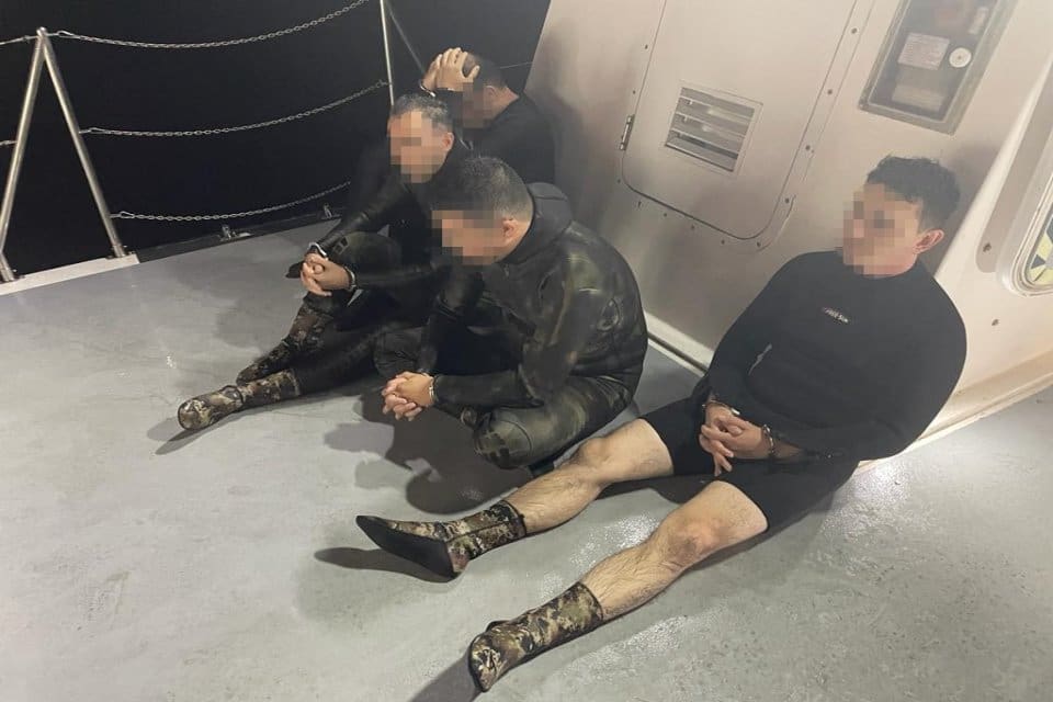 Muğla&rsquo;nın Bodrum il&ccedil;esinde giydikleri dalgı&ccedil; elbiseleri ile y&uuml;zerek Yunanistan adalarına