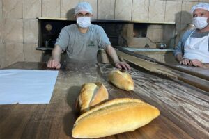 İzmir'de Hasan Durmuş (50), çalıştığı fırında bir yandan ekmek üretiyor