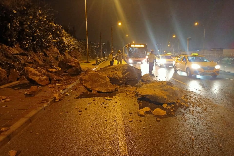 İzmir'in Bayraklı il&ccedil;esinde yağmur sularının etkisiyle yama&ccedil;tan&nbsp;d&uuml;şen kaya par&ccedil;aları yolu