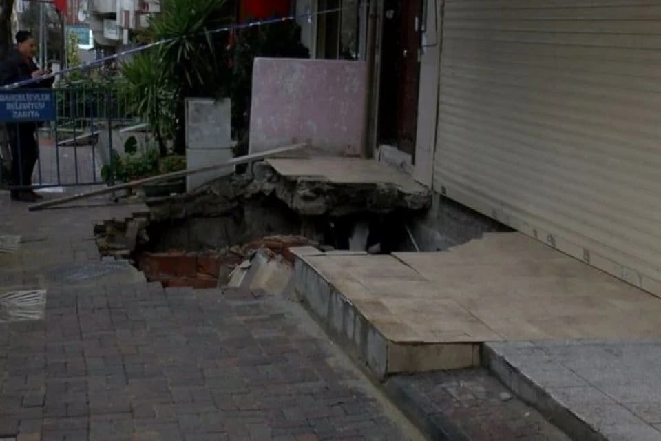 Bah&ccedil;elievler'de bulunan 7 katlı apartmanın &ouml;n&uuml;ndeki kaldırım, altındaki k&ouml;m&uuml;rl&uuml;ğe doğru