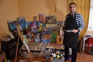 İzmir'de otizmli Erkan Kızıldağ (30), &ccedil;eşitli malzemeler kullanarak yaptığı resimlerle