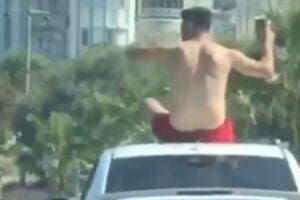 AYDIN'ın Kuşadası il&ccedil;esinde, otomobilin tavanında oturarak seyahat eden kişi hem
