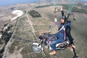 Yamaç paraşütü pilotu Hasan Kaval, paraşütüne bağladığı motosikletle Pamukkale'nin beyaz
