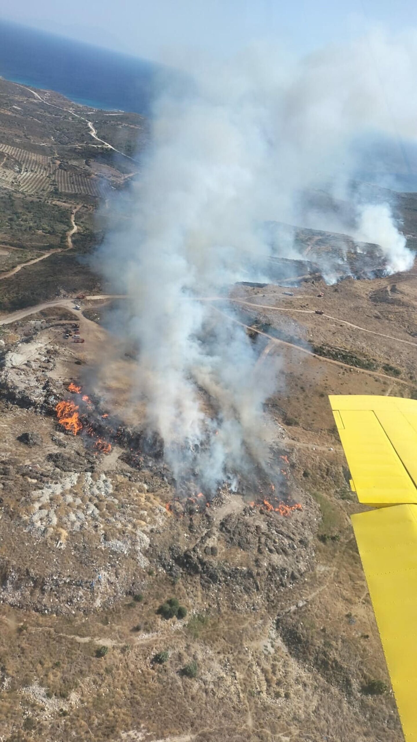 İzmir'in Çeşme ilçesinde çöplükte çıkıp ormana sıçrayan yangına ekipler, alevlere