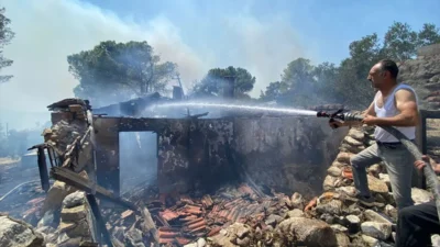 İzmir'in Karaburun ilçesinde çıkan orman yangını yerleşim yerlerine doğru ilerliyor.