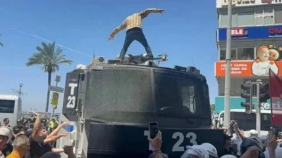 İzmir’de Valiliğin miting yasağını protesto ederken polis aracının üzerine çıkan