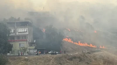 İzmir'in Karşıyaka ilçesinde otluk alanda çıkan yangın, şiddetli rüzgarın etkisiyle